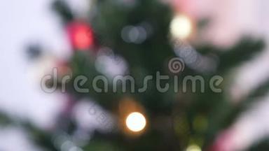 圣诞树树枝上的红色闪亮的球和金色玩具.. 圣诞树上有灯光的圣诞花环